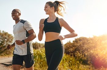 man and women running outside smiling 